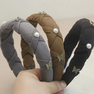 Detail view of velvet padded headbands with rhinestone butterfly and pearl accents