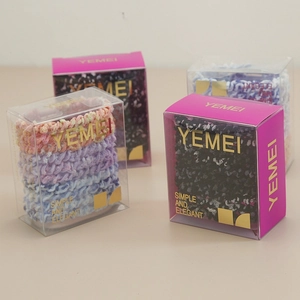 Detail showing four sets of elastic knitted hair scrunchies in transparent PVC gift boxes