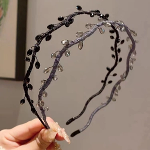 Detailed close-up of woven crystal beaded headbands in black and silver metallic wire
