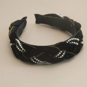 Close-up of black velvet braided headband with white pearls and gold thread edges