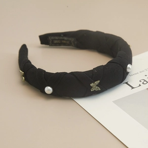 Detail of black pleated headband with white pearls and gold rhinestone butterfly charm