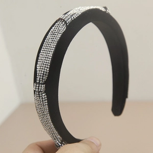 Detailed view of the sparkling rhinestones and black velvet fabric on the headband