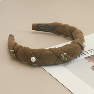 Detail of dark brown braided headband featuring pearls and golden rhinestone butterflies