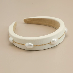 Close-up of vintage pearl sponge headband with silk texture and golden chain detail