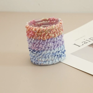Close-up of three knitted elastic hair bands with woven texture in pastel color palette
