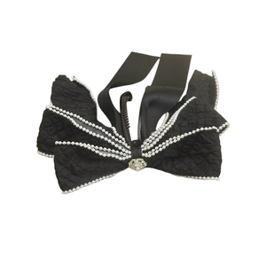Clip de plátano elegante con lazo negro, camelia blanca y perlas delicadas