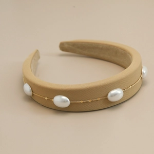 Detail view of khaki sponge headband with gold chain and white faux pearls