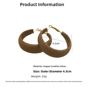Detailed view of 4.5cm brown leather wrapped C-shape hoop earring with copper details