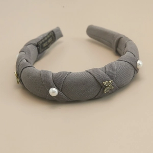 Detail of grey fabric headband with white pearls and sparkling crystal butterfly accents