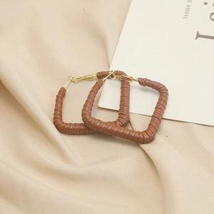 Detail of brown faux leather rectangular hoop earrings with elegant gold metallic clasp