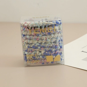 Détail d'élastiques à cheveux colorés en laine dans une boîte cadeau élégante