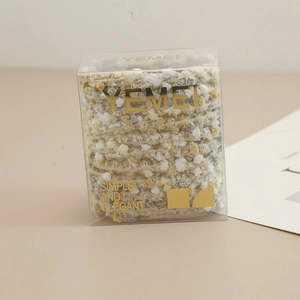 Détail d'élastiques à cheveux en laine multicolore douce dans une boîte minimaliste