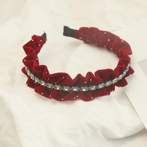 Detail des weinroten Samtstirnbands mit glänzenden Strasssteinen und gerafftem Design