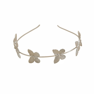 Close-up of silver metal butterfly headband with detailed wing textures on a white background
