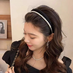 Détail du serre-tête élégant en satin noir à double couche avec perles sur un modèle