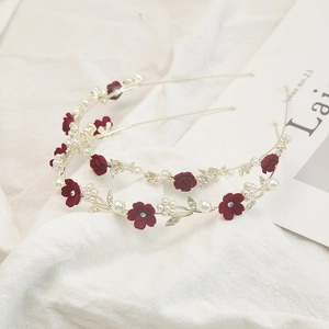 Détail d'un serre-tête en fleurs de velours avec perles blanches et strass brillants