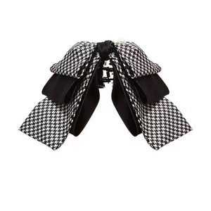Elegant houndstooth and black ribbon hair claw clip with a decorative white pearl detail