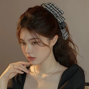 Détail d'une barrette à cheveux nœud en tweed noir et blanc élégant avec perles