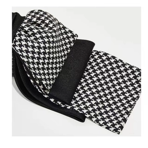 Detailed close-up showing the layered houndstooth and satin fabric of the bow hair clip