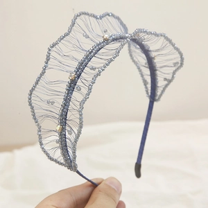 Detail of blue beaded headband featuring woven mesh design and sparkling gold rhinestones