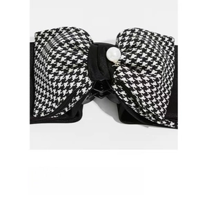 Detail of large houndstooth bow hair claw clip with elegant faux pearl embellishment