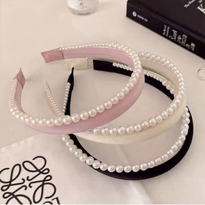 Détail de serre-têtes élégants en satin avec perles en rose, blanc cassé et noir profond