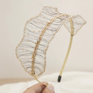 Detailed view of handmade wavy gold beaded headband with rhinestones and mesh design
