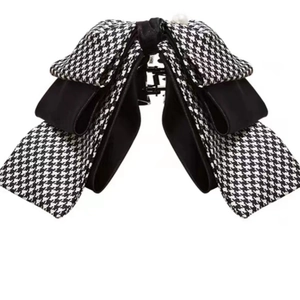 Detail of layered houndstooth bow hair claw clip with white faux pearl embellishment