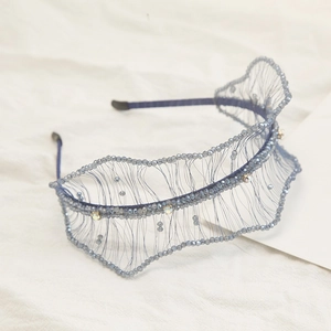 Detail of greyish-blue crystal beaded headband with intricate wave mesh and rhinestones