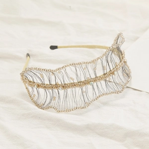 Detailed view of champagne beaded weave headband with gold leaf-shaped mesh design