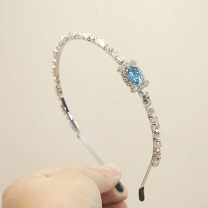 Eleganter Haarreif aus Silberkristall mit blauem Edelstein auf neutralem Hintergrund