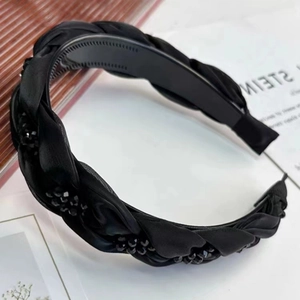 Détail d'un serre-tête tressé noir avec strass brillants et dents intérieures antidérapantes