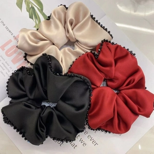 Trois chouchous en satin premium en or champagne, noir et rouge avec garniture perlée
