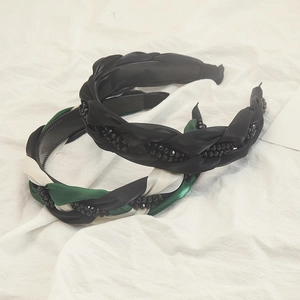 Détail d'un serre-tête tressé à la main avec strass noirs et peigne intérieur de maintien