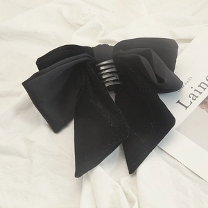 Elegant black velvet bow hair claw clip with shimmering details on a white background