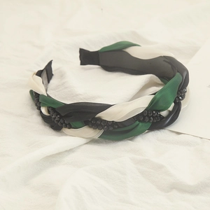 Détail du serre-tête tressé tricolore vert, noir, blanc avec perles noires incrustées