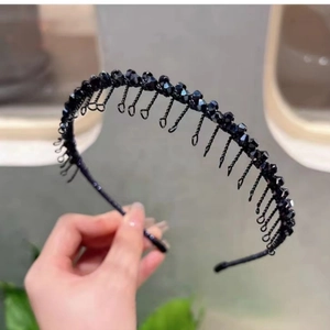 Détail des dents de peigne internes et des perles noires facettées sur le bandeau