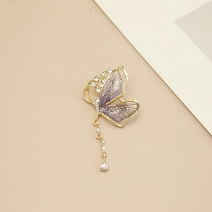 Élégante broche papillon dorée avec ailes violettes et pampilles scintillantes en strass