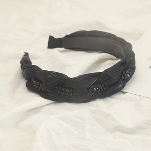 Détail du serre-tête torsadé à strass noirs avec dents antidérapantes et perles élégantes