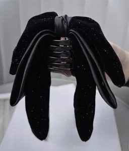 Detail of black velvet bow hair claw clip with fine glitter and dense teeth structure