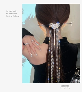 Macro view of silver heart hair pin with sparkling long crystal tassels on a model