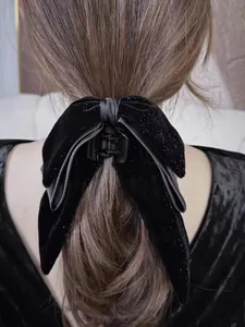 Close-up of black velvet hair claw clip with subtle glitter on a woman's long hair
