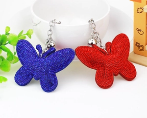 Close-up of velvet butterfly keychains with rhinestones, silver bells and chain details