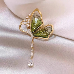 Détail de broche papillon émeraude avec ailes vertes et pendentif en zircone