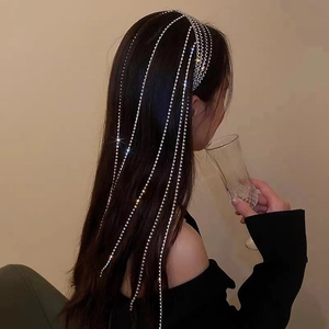 Detailed view of long sparkling rhinestone fringe hairpins on a model for elegant styling