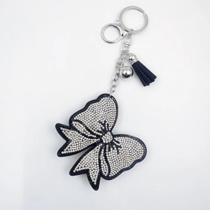 Porte-clés avec nœud en cristal étincelant, pompons noirs et fermoir en métal argenté