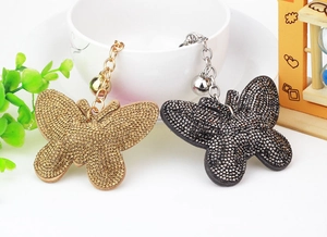 Detail of velvet butterfly keychains with rhinestones and bells in gold and black