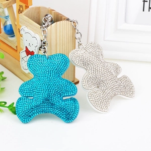 Close-up of sparkling blue and silver rhinestone bear keychains on a display stand
