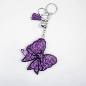 Porte-clés nœud en cristal étincelant avec pompons en velours violet et clochette