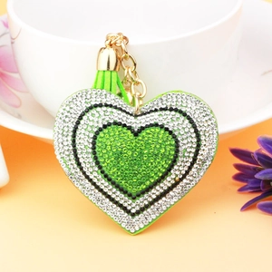 Detailed macro view of heart-shaped keychain with green rhinestones and tassel